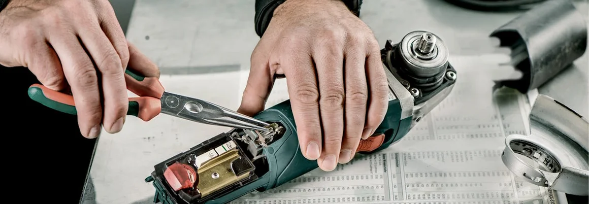 Person repariert Werkzeug mit Zange